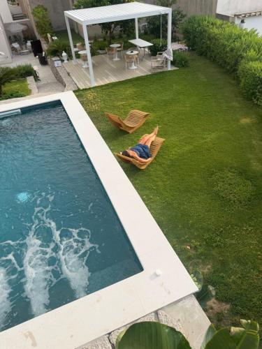 a person laying in a lawn chair next to a swimming pool at Amamì B&B in Anacapri