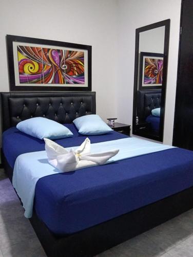 a bedroom with two beds with blue sheets at Hospedaje Luna Dorada in Manizales