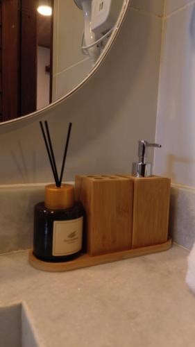 a bathroom sink with a soap dispenser and a mirror at Pousada Angelim in Santo Amaro