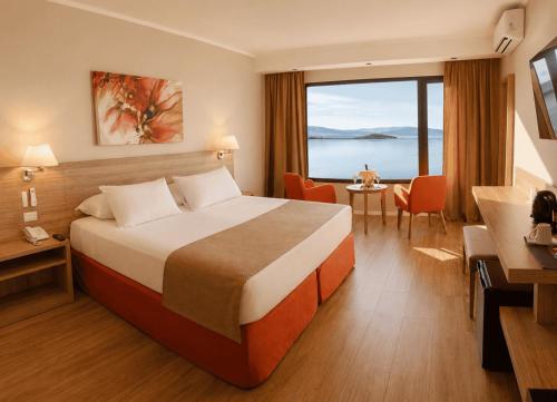 a hotel room with a bed and a large window at Xelena Hotel & Suites in El Calafate