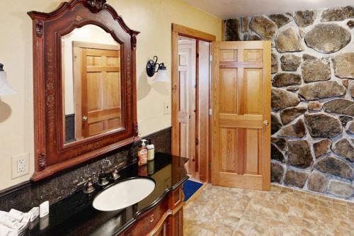 a bathroom with a sink and a stone wall at Justin Lake Lodge in Londonderry