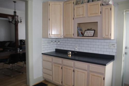 a kitchen with white cabinets and a black counter top at The Polished Plank in Kokomo