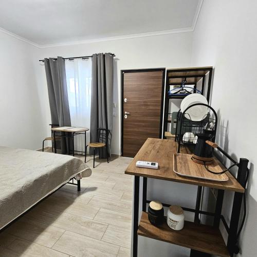 a bedroom with a bed and a wooden table at Garden Room with Private Patio Salamis in Eantio