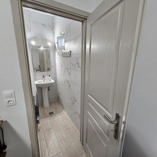 a bathroom with a shower door and a sink at Garden Room with Private Patio Salamis in Eantio