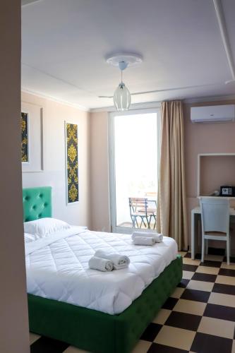 a bedroom with a large bed with towels on it at Esal Hotel in Durrës