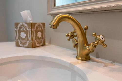a bathroom sink with a gold faucet on a counter at Luxury Gites de Chateau Mirabel - Latour - with saltwater swimming pool and AC in Puylaurens