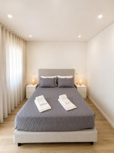 a bedroom with a bed with two towels on it at Casa do Leme in Nazaré