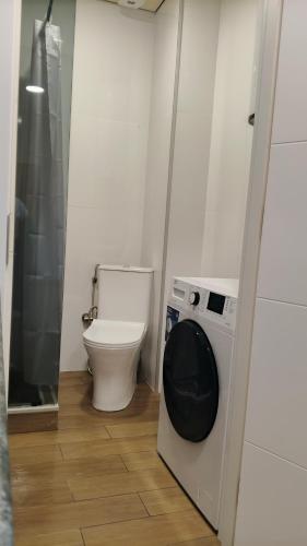 a bathroom with a toilet and a washing machine at Ureki Sun Estate in Ureki
