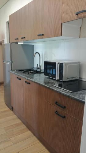 a kitchen with a microwave and a counter top at Ureki Sun Estate in Ureki