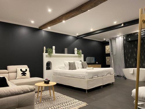 a bedroom with a bed and a couch and a table at Mas Beauregard in Anduze