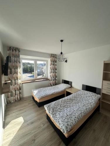 two beds in a room with a window at Królewska Przystań in Kamienica Królewska