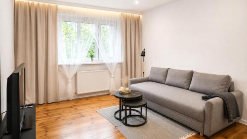 a living room with a couch and a television at Bytom Apartament 24H in Bytom