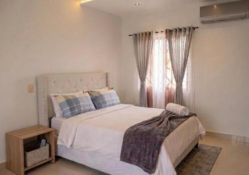 a bedroom with a large bed and a window at Villa renacer in Baní