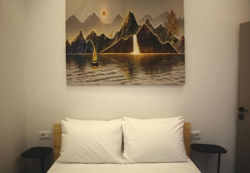 a bedroom with a bed with a painting on the wall at Lazari S Apartments in Himare