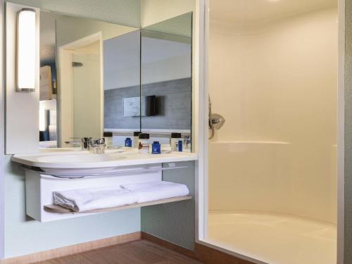 a bathroom with a sink and a mirror at ibis budget Meudon Paris Ouest in Meudon