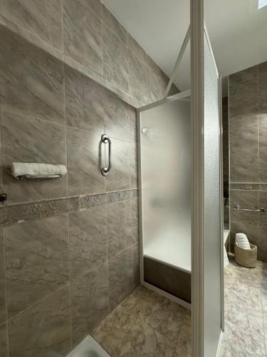 a shower with a glass door in a bathroom at La terraza del Campanario in Ríolobos