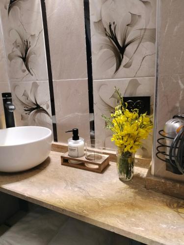 a bathroom with a sink and a vase of yellow flowers at Baykus Deluxe in Kuşadası