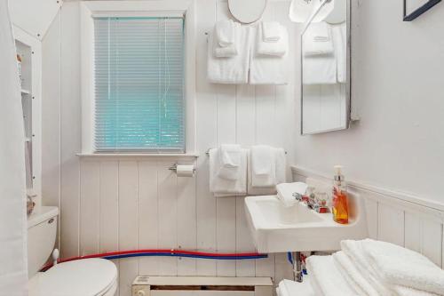 a white bathroom with a toilet and a sink at The Koliba in Windham
