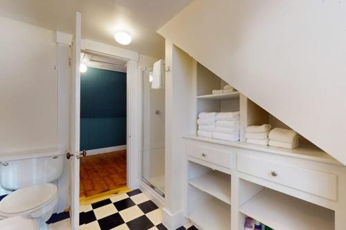 a bathroom with a toilet and a staircase with towels at Green Door Cottage in Weston
