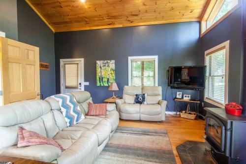 a living room with a white couch and chairs at Misty Mountain Cabin in Lenoir