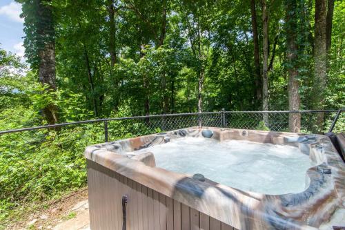 a hot tub in the middle of the woods at Misty Mountain Cabin in Lenoir