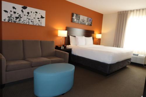 a hotel room with a bed and a couch at Sleep Inn & Suites Oregon - Madison in Oregon