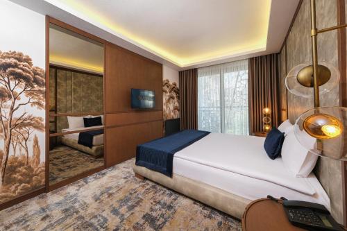 a bedroom with a bed and a desk with a computer at The Alpfine Hotel in Ankara