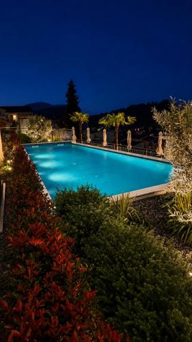 a large blue swimming pool at night at Olive apartments in Petrovac na Moru