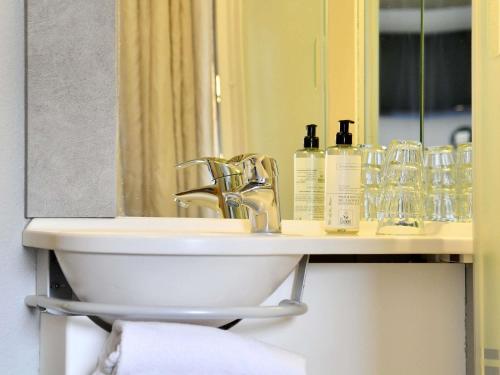a bathroom with a sink and a mirror at ibis budget Cholet Centre in Cholet