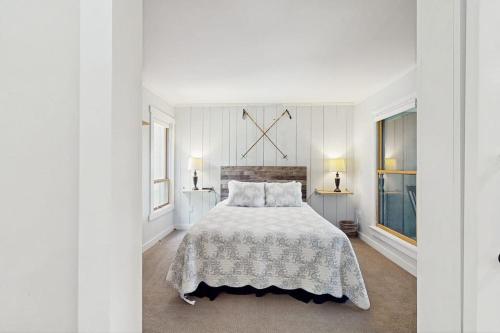 a white bedroom with a large bed and two windows at North Lynx 11 in Warren