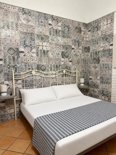 a bedroom with a bed and a tile wall at Lauro Apartment in Meta