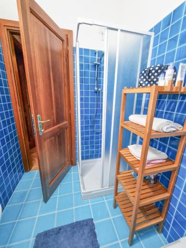 a blue tiled bathroom with a shower and a ladder at Villa Angedras in San Teodoro