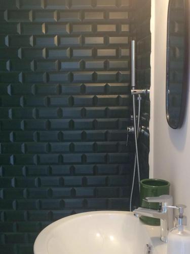 a bathroom with a white sink and a brick wall at Tolomeo's House-Bed & Bike in Nardò