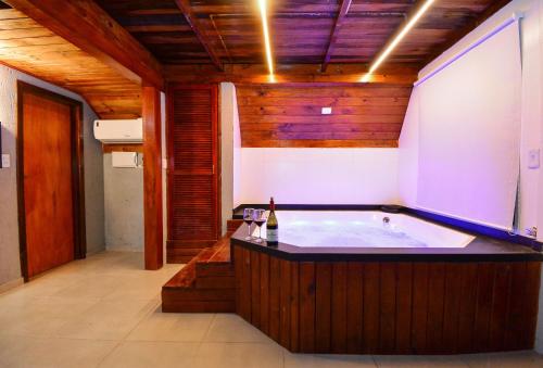 a jacuzzi tub in a room with wooden walls at Chalé com Jacuzzi e Vista Mar - PLH007 in Palhoça