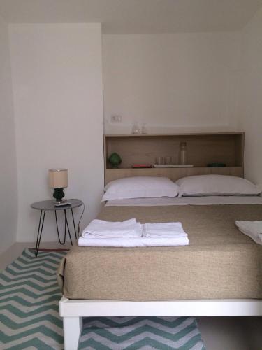 a bedroom with two beds and a table with a lamp at Tolomeo's House-Bed & Bike in Nardò