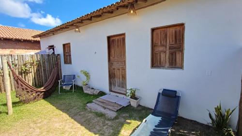 a white house with wooden doors and a hammock at Casa Mar in Caraíva