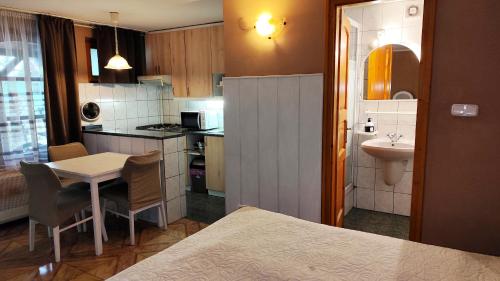 a small kitchen with a table and a sink at Katica Vendégház in Siófok