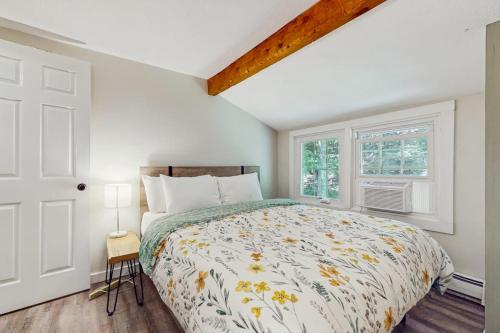 a bedroom with a bed and two windows at Quechee Hollow 1F in Quechee