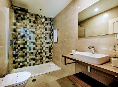 a bathroom with a sink and a toilet and a tub at Villa Waterside in Luz