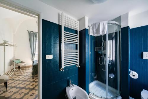 a blue bathroom with a shower and a tub at Casa Superga by Rentbeat in Cisternino