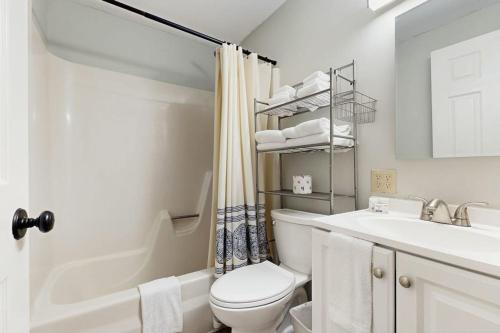 a white bathroom with a toilet and a sink at Quechee Hollow 2C in Quechee