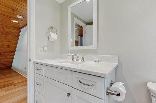 a white bathroom with a sink and a mirror at Frozen Jamaica in Jamaica
