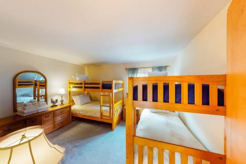 a bedroom with two bunk beds and a mirror at Mountainside Resort H203 in Stowe