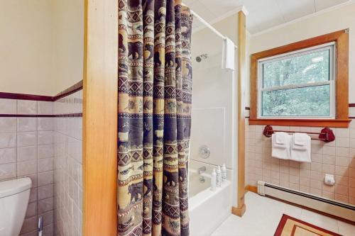 a bathroom with a toilet and a shower curtain at North Hill Cross Retreat in Ludlow