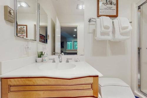 a white bathroom with a sink and a mirror at Slopeside A2 in Stratton