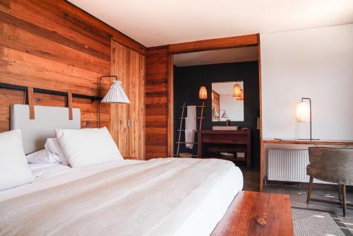 a bedroom with a large bed and a desk at Hotel Alaia in Pichilemu