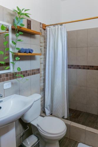 a bathroom with a toilet and a sink and a shower at Casa Ramona in Flores