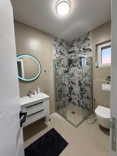 a bathroom with a shower and a sink and a toilet at Villa Elaris in Bihać