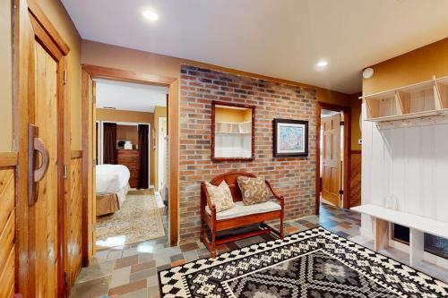 a room with a brick wall with a chair and a bed at The Nest in Irasville