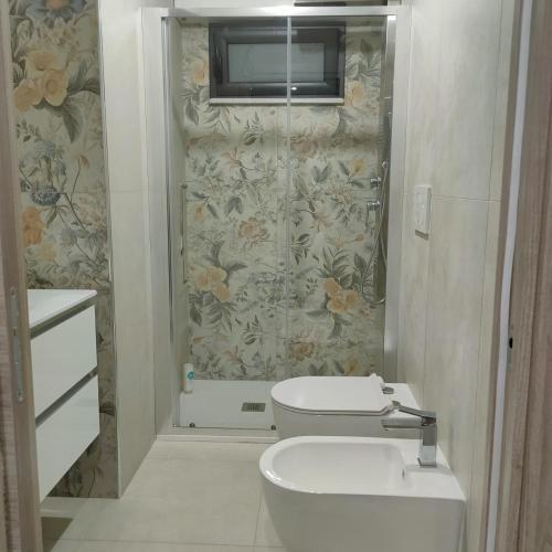 a bathroom with a toilet and a television on the wall at ANAMI' Suite Apartament in Bovalino Marina